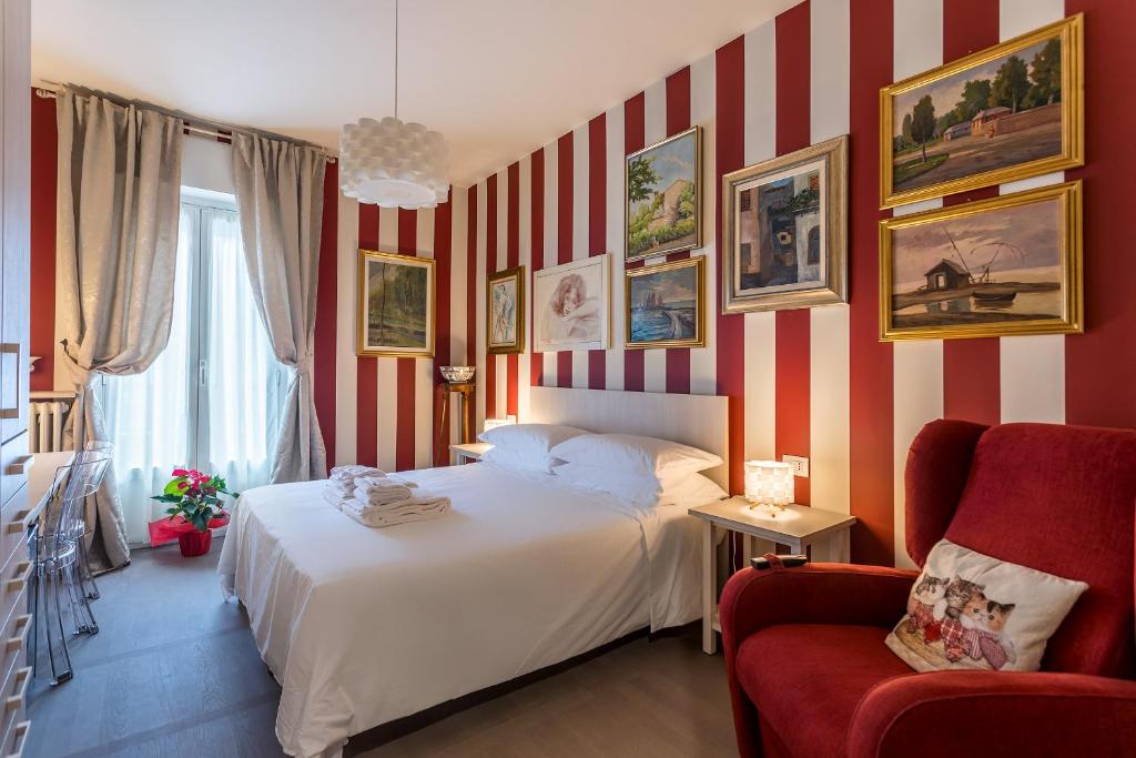 1 dormitorio con cama y pared de rayas rojas y blancas en Casa Vacanze In Arte Milano, en Milán
