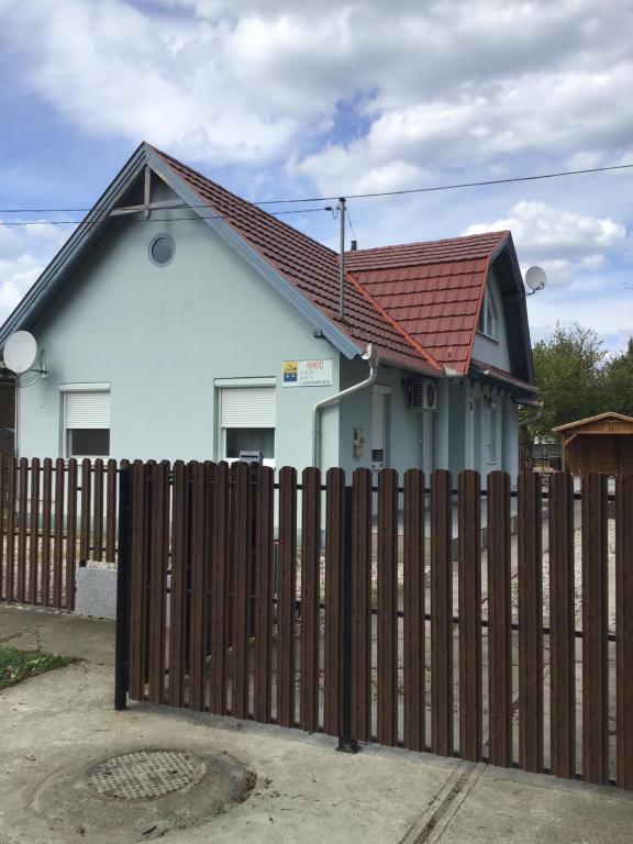 a house with a wooden fence in front of it at 4 Lurkó Apartman Új in Hajdúszoboszló