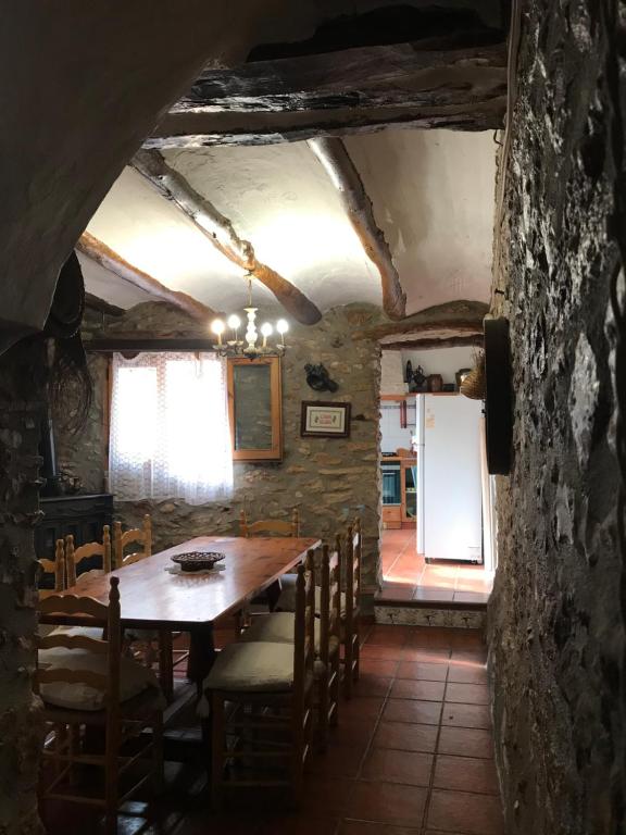 a dining room with a wooden table and chairs at CASA ELISA in Masdenverge