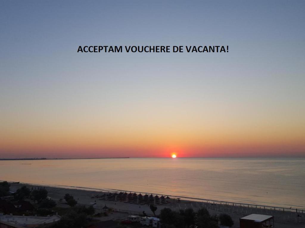 a sunset over the ocean with the words acropán volunteer de vazarin at Lotus nr 9 Mamaia Apartments Sea View in Mamaia