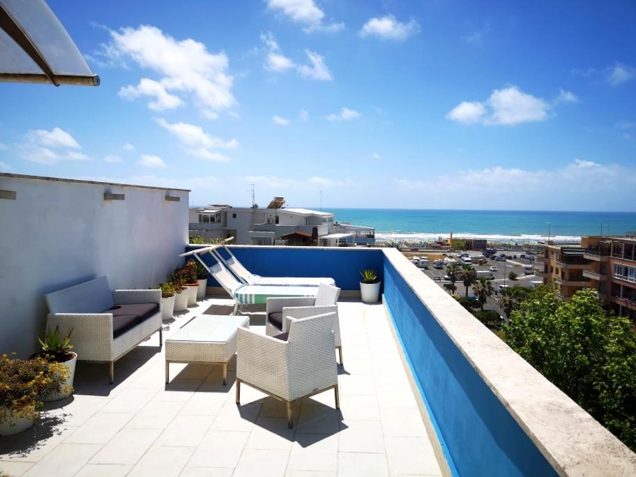 a balcony with chairs and a view of the ocean at Attico LUX in Lido di Ostia