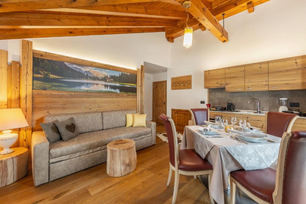 a living room with a table and a couch at Chalet Mountain Plaza - Apt Homewood in Pinzolo