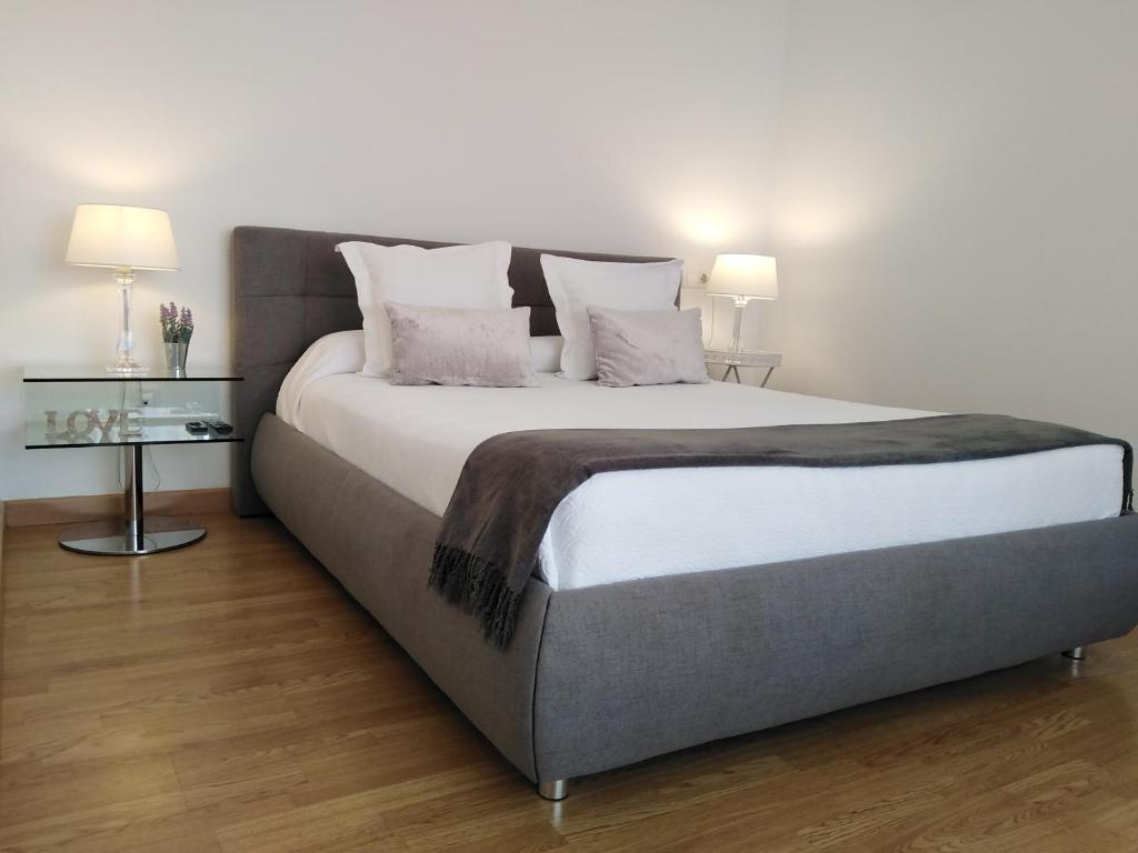 a large bed in a room with two lamps at Sevilla Aljarafe Room in Bormujos