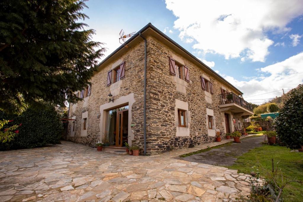 une maison en pierre avec une allée en pierre en face de celle-ci dans l'établissement Vieiro Verde, à Vieiro