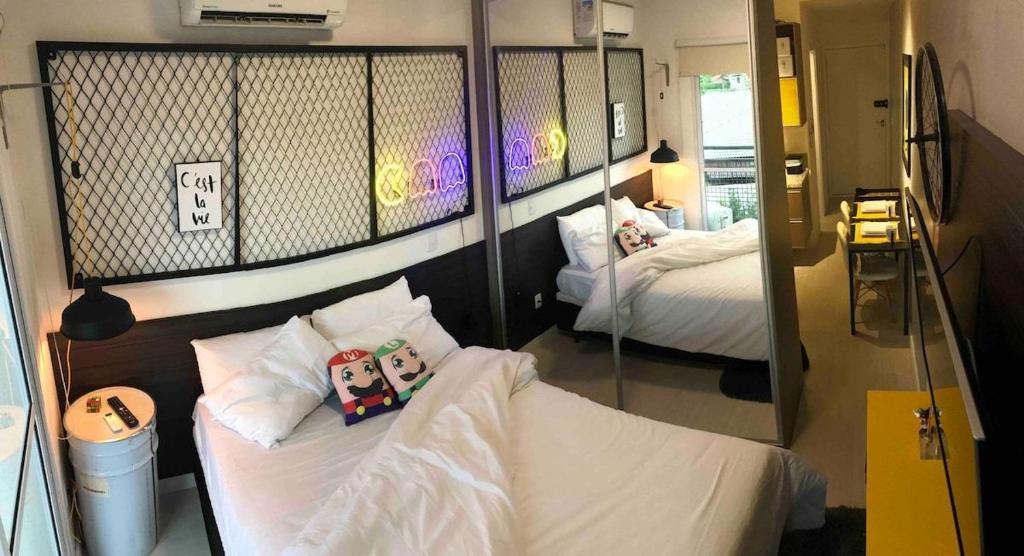 ein Zimmer mit zwei Betten und einem Spiegel in der Unterkunft Granja Viana Studio 429 decoracao industrial in Cotia