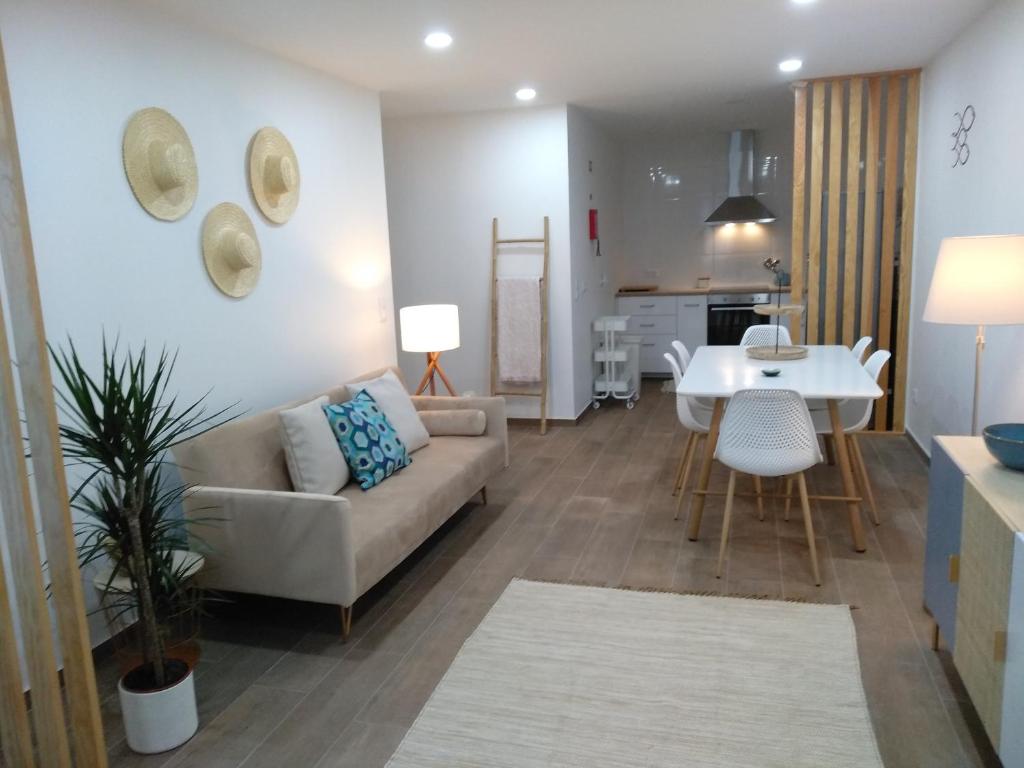 ein Wohnzimmer und eine Küche mit einer Couch und einem Tisch in der Unterkunft Apartamentos Areia e Mar Norte in Vila Praia de Âncora