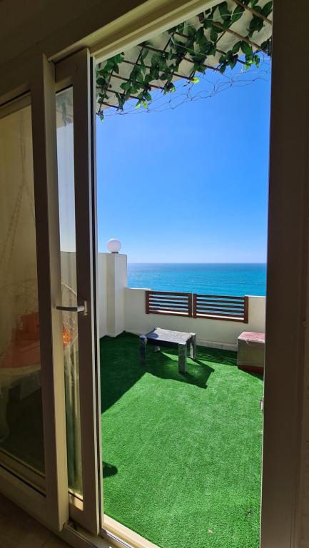 a room with a view of the ocean through a sliding glass door at Hyat Hostel & Suites in Alexandria