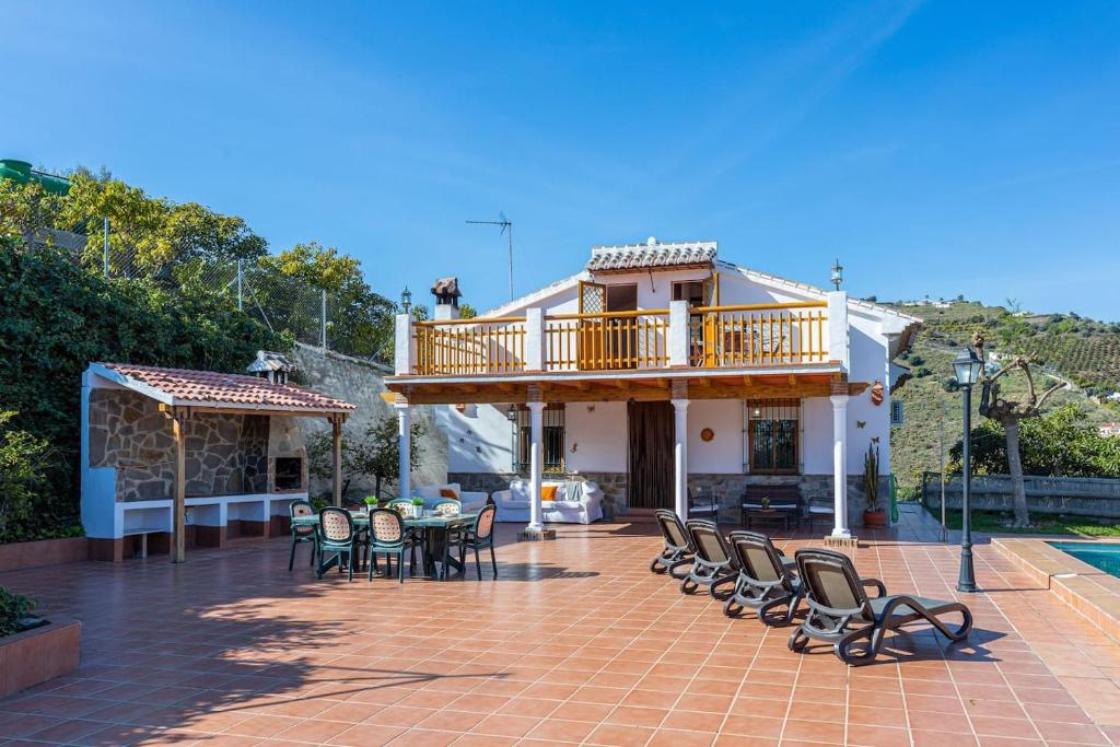 un patio con sedie, un tavolo e un balcone di Villa Relax Solset a Frigiliana