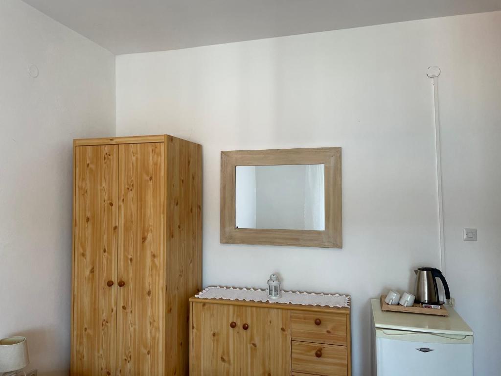 een badkamer met een houten kast en een spiegel bij Guesthouse Tariba in Supetarska Draga