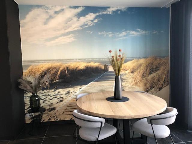 jadalnia ze stołem i obrazem plaży w obiekcie BLOC 79/ THREE w mieście Knokke-Heist