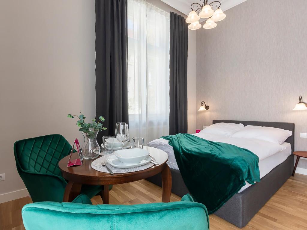a hotel room with a bed and a table and chairs at VacationClub – Wisus Apartament 19 in Świnoujście