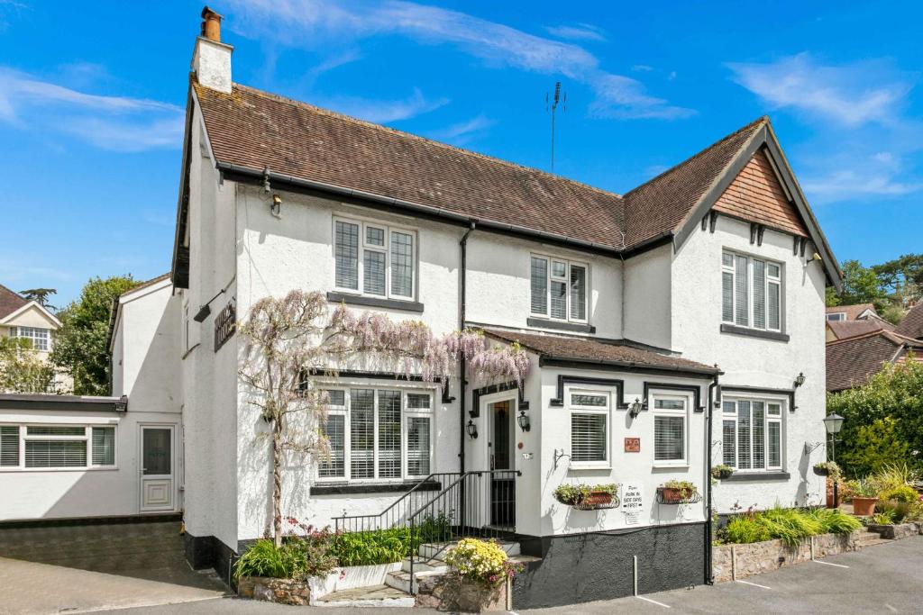 una casa blanca con techo negro en Stover Lodge, en Torquay