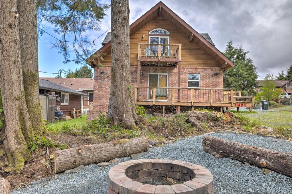 a log house with a fire pit in front of it at Rockaway Beach Hideaway with Hot Tub and Fireplace! in Rockaway Beach