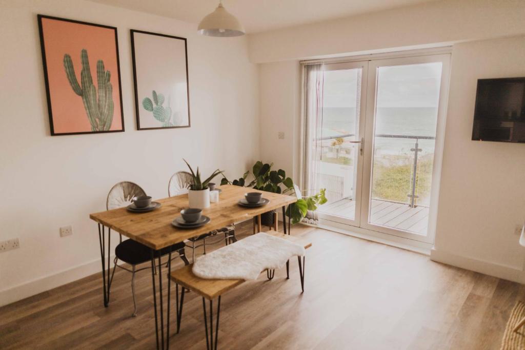a dining room with a table and a large window at Ocean 1- Sea View apartment, Fistral Beach Newquay in Newquay