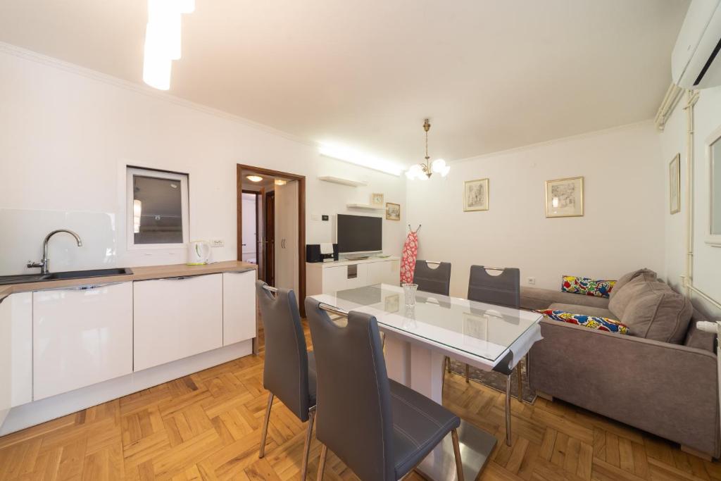 a kitchen and living room with a table and a couch at Apartment Trešnja in Zagreb