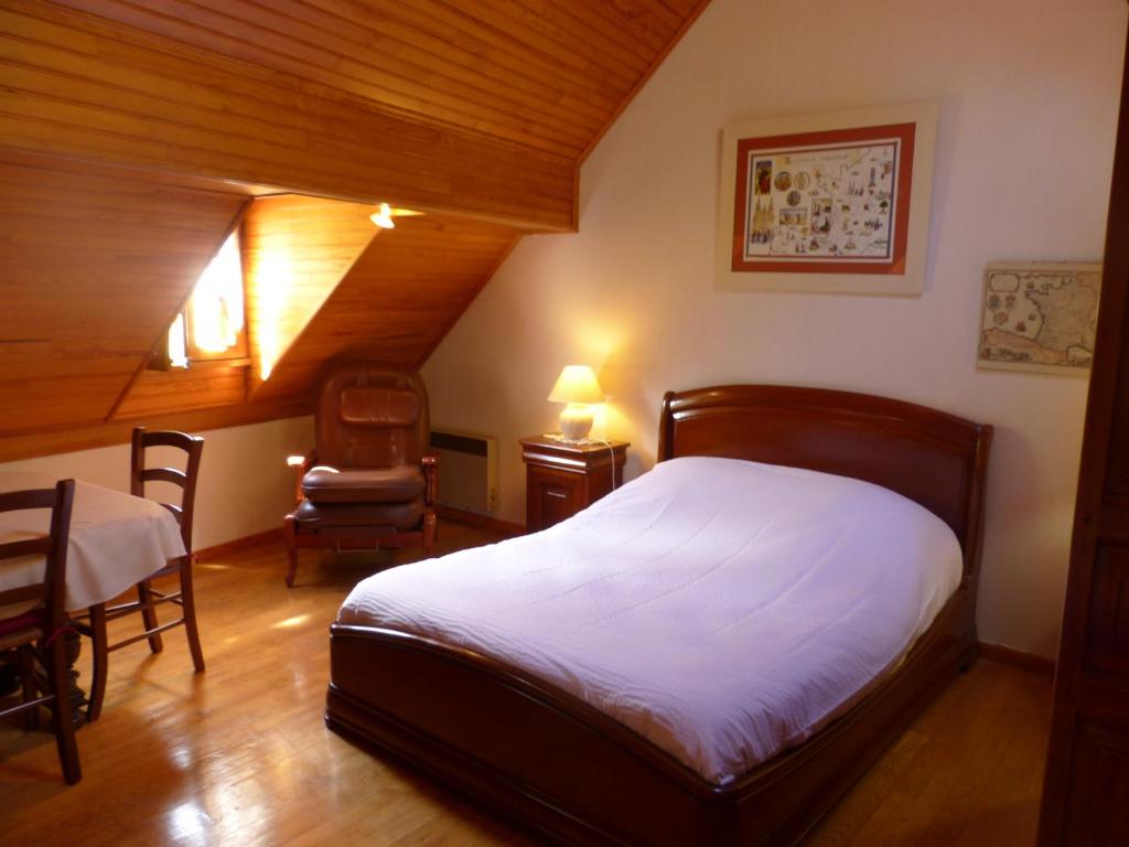 ein Schlafzimmer mit einem Bett, einem Tisch und einem Stuhl in der Unterkunft LA Bouigane in Saint-Lary-Soulan