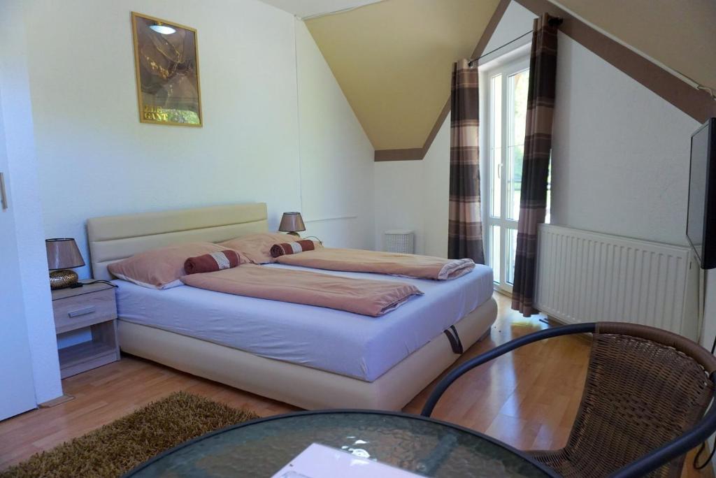 a small bedroom with a bed and a glass table at Berg Szállás in Sátoraljaújhely