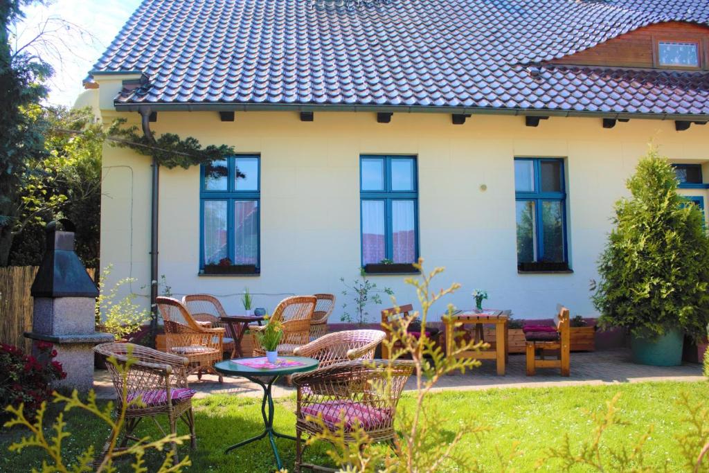 ein Haus mit Stühlen und einem Tisch im Hof in der Unterkunft Zum Alten Schulhaus in Burg