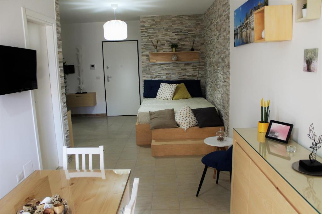 Casa Angelina Deluxe Suite في ليتشي: غرفة نوم صغيرة بها سرير ومطبخ