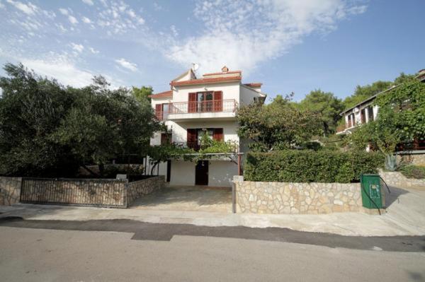 a large white house with a fence and a street at APARTMENTS Vuković in Vrboska
