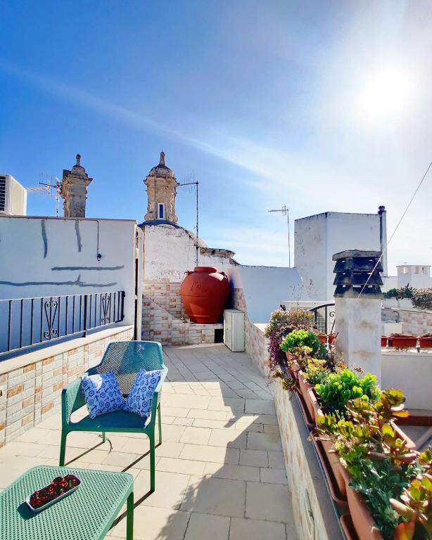 patio z dwoma krzesłami i roślinami na dachu w obiekcie C'era una Volta Apartments w mieście Polignano a Mare