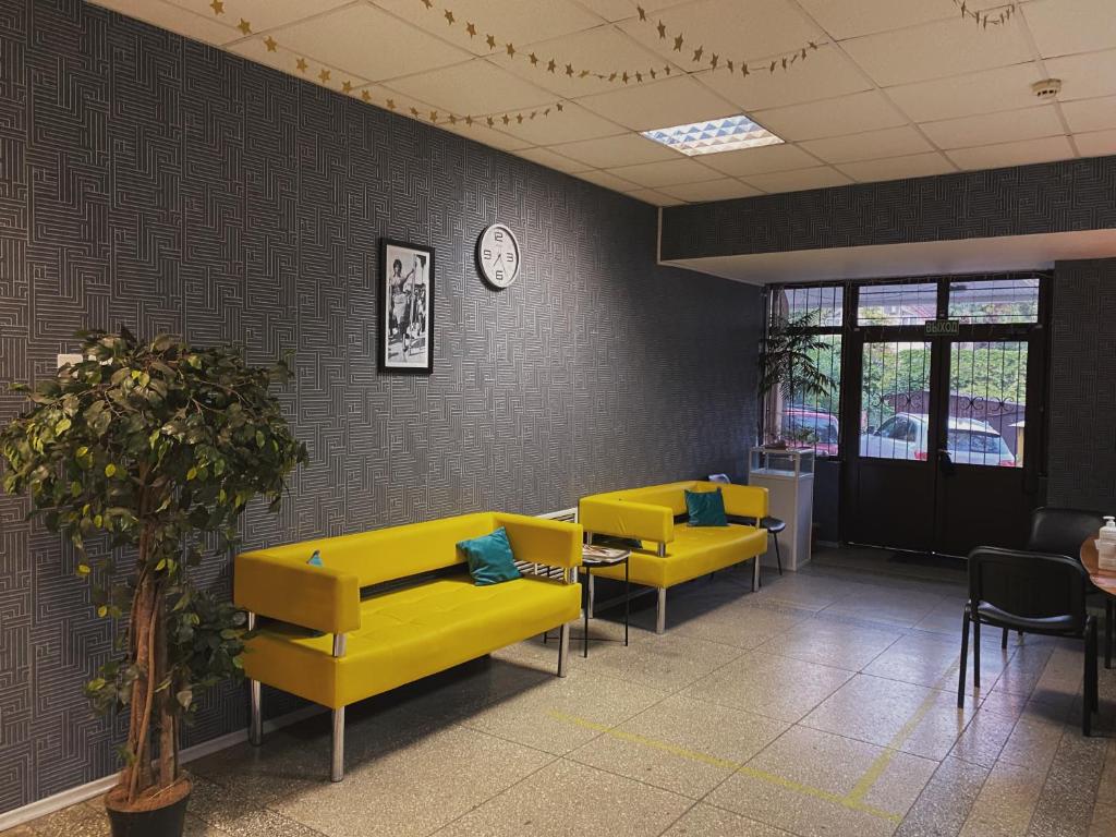 a waiting room with yellow couches and tables at Hostel on Komsomolskaya in Sochi