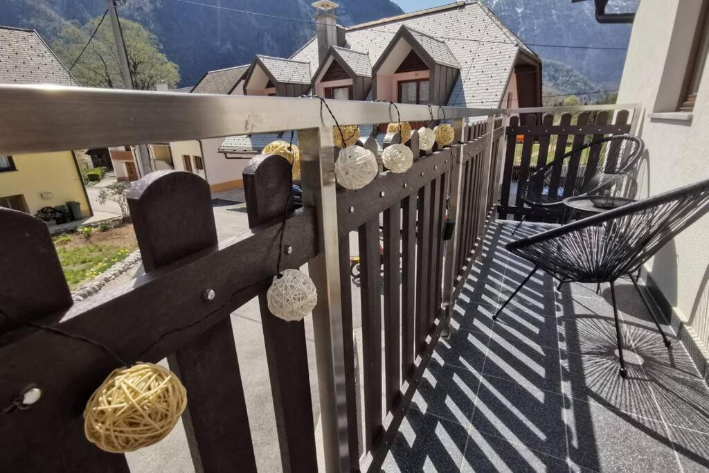 einen Balkon mit einem Zaun mit Stühlen und einem Sonnenschirm in der Unterkunft My House in Bovec