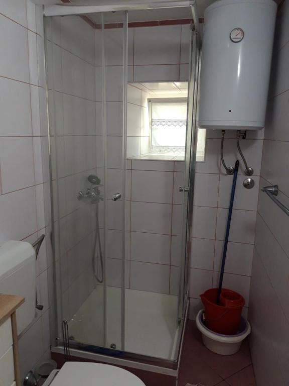 a bathroom with a shower with a toilet and a window at Guesthouse Palma in Mali Lošinj