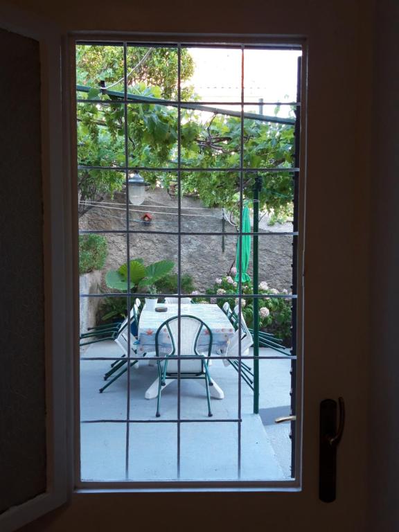 a window with a view of a patio with a chair at Guesthouse Palma in Mali Lošinj