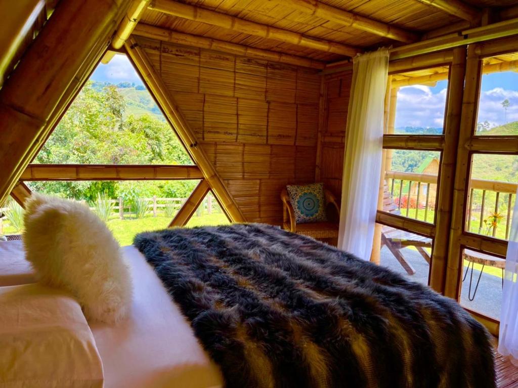 un grande letto in una stanza con una grande finestra di Glamping La Herradura a Santa Rosa de Cabal