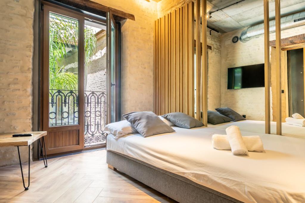 a bedroom with a large bed and a large window at Santa Clara Suites Sevilla in Seville