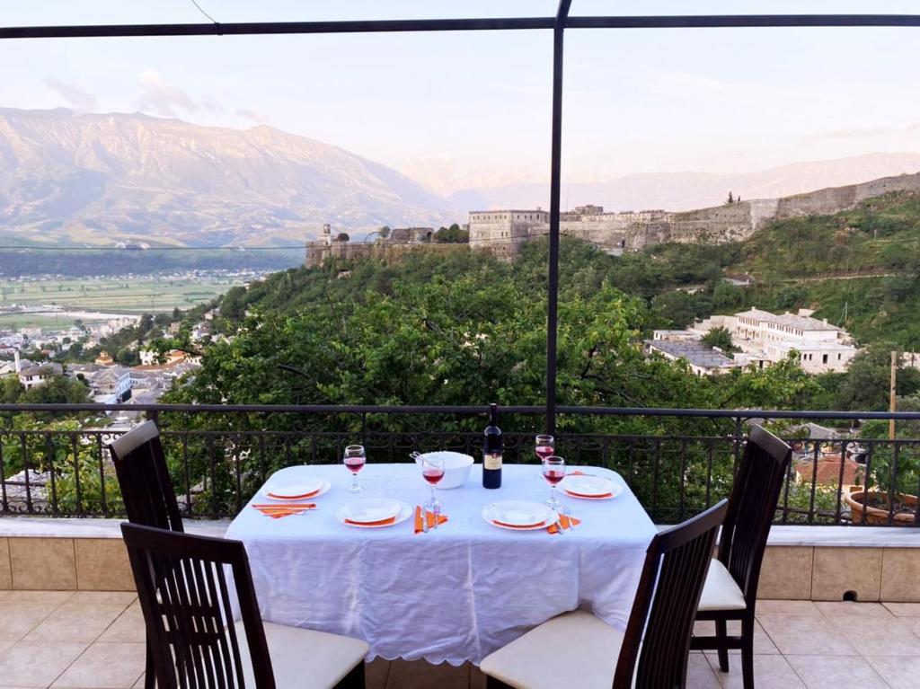 einen Tisch mit Gläsern Wein und Stadtblick in der Unterkunft Inn Cloud Gjirokaster in Gjirokastër