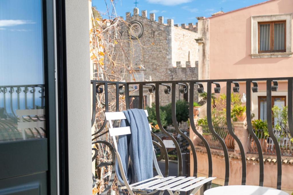 una toalla en una silla en un balcón en Longo Suites en Taormina