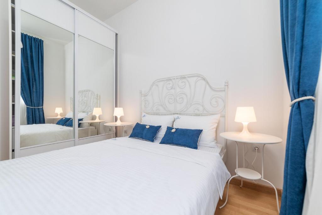 um quarto com uma grande cama branca e um espelho em Ana`s apartment Budva MNE em Budva