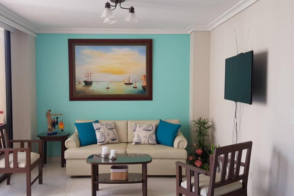 ein Wohnzimmer mit einem Sofa und einem Gemälde an der Wand in der Unterkunft Hermoso Apartamento en el Condominio Nuevo Rodadero in Santa Marta