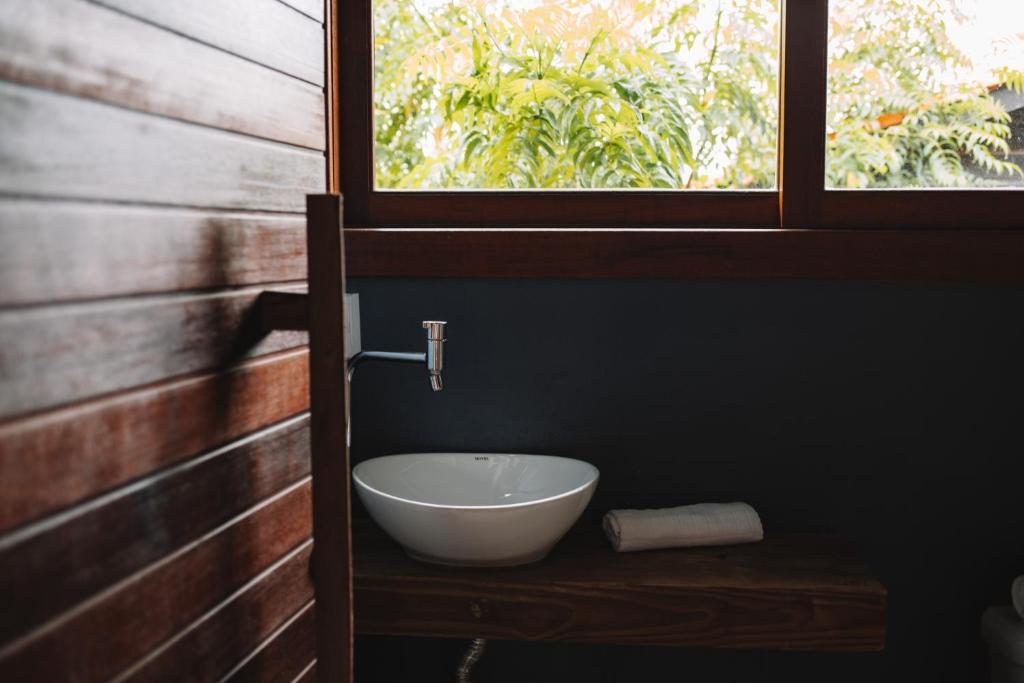 ein Badezimmer mit einem Waschbecken auf einem Holztisch in der Unterkunft Sapê Guest Hotel in Praia do Rosa