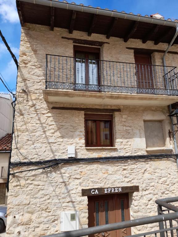 a stone building with a balcony on top of it at CA EFREN in Castellfort