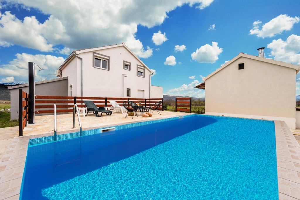 a blue swimming pool in front of a house at Nerona in Bisko