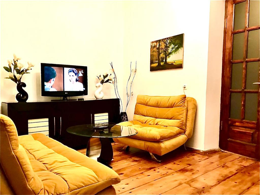 een woonkamer met een bank en een tafel bij Rezis sweet home in Tbilisi City