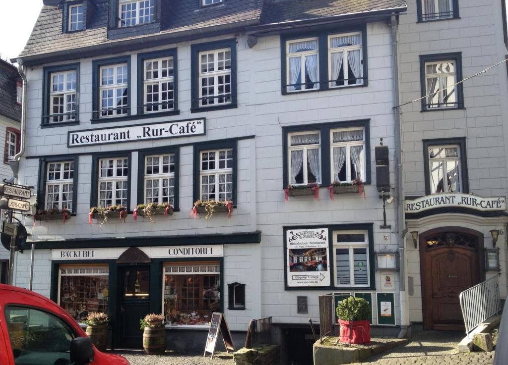 a large white building with windows on a street at Ferienwohnung am Markt in Monschau