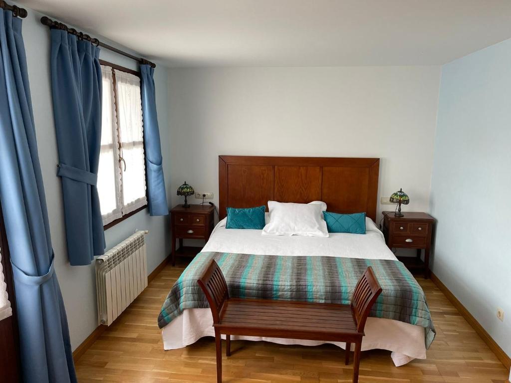 um quarto com uma cama grande e cortinas azuis em LA CASONA DE RALES VILLAVICIOSA em Rales