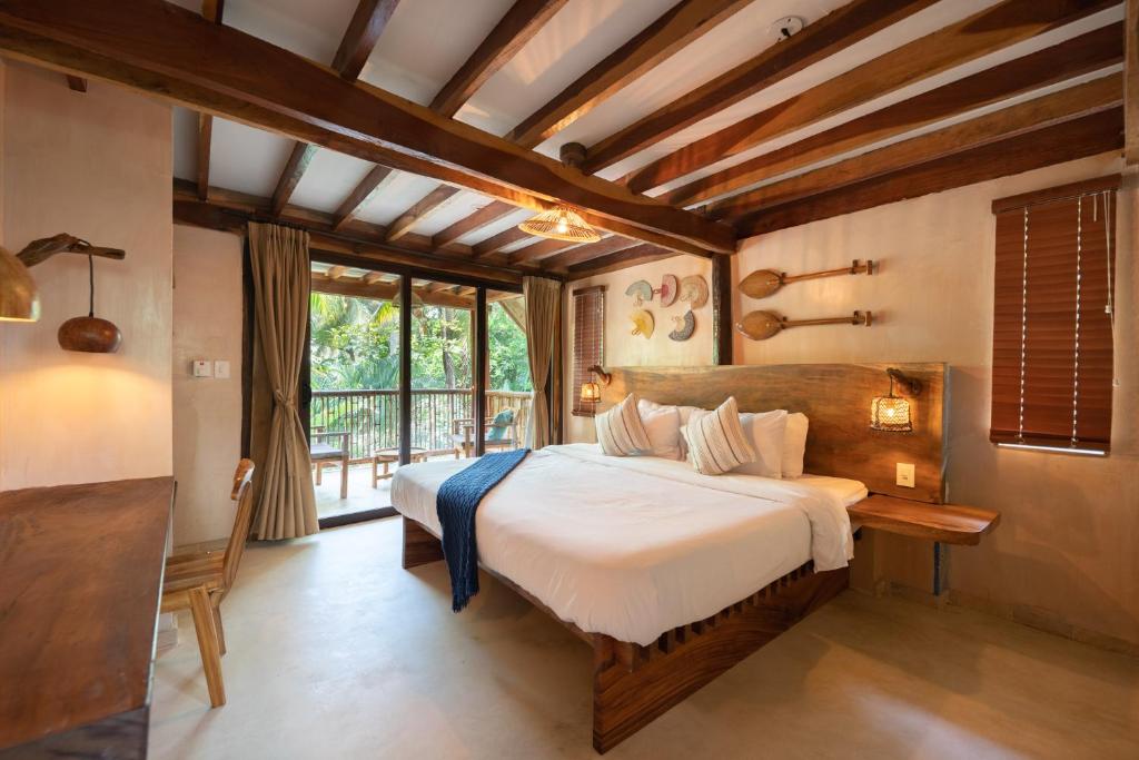 a bedroom with a large bed and a balcony at La Brisa Tranquila in Guachaca