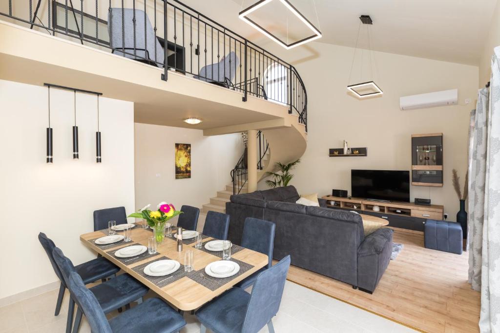 Vitality Villa Mariante - free kajaks, sauna في Komolac: غرفة طعام وغرفة معيشة مع طاولة وكراسي