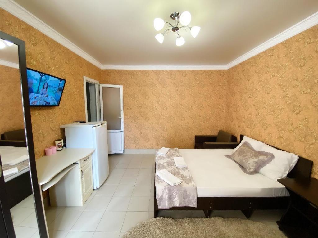 ノヴォミハイロフスキーにあるGuest House Маргаритаのベッドとキッチン付きの小さな部屋