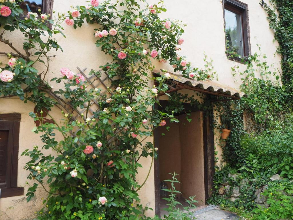 a building with roses climbing up the side of it at Gîte Tanagra : Maison avec piscine et vue exceptionnelle in Roquefort-les-Cascades