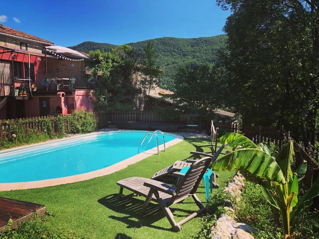 a pool with two lounge chairs next to a house at Gîte Tanagra : Maison avec piscine et vue exceptionnelle in Roquefort-les-Cascades