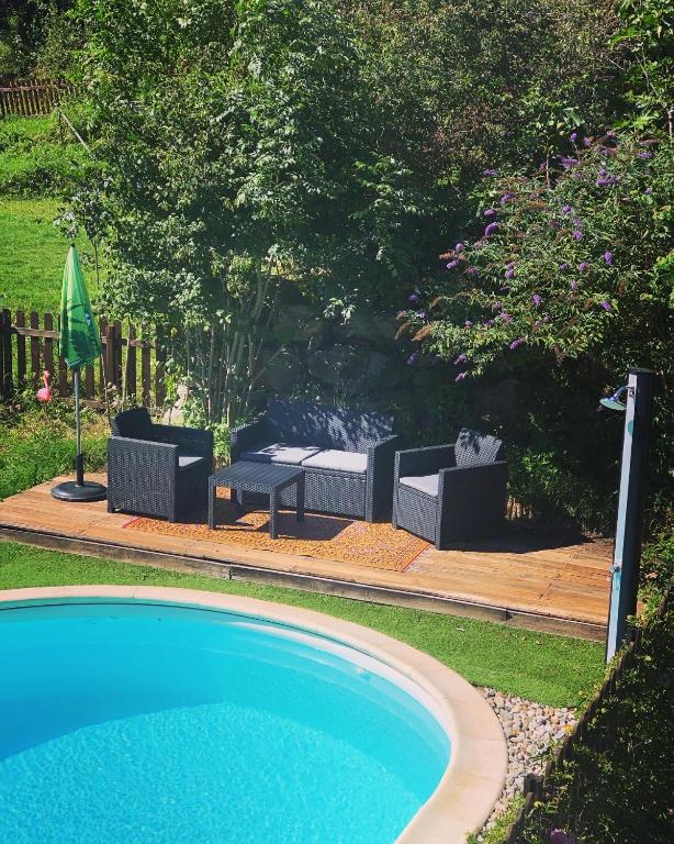 a swimming pool with two chairs and a fire place at Gîte Tanagra : Maison avec piscine et vue exceptionnelle in Roquefort-les-Cascades