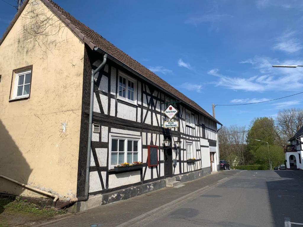 een oud zwart-wit gebouw in een straat bij Landgasthof Zum Dorfkrug in Schöneberg