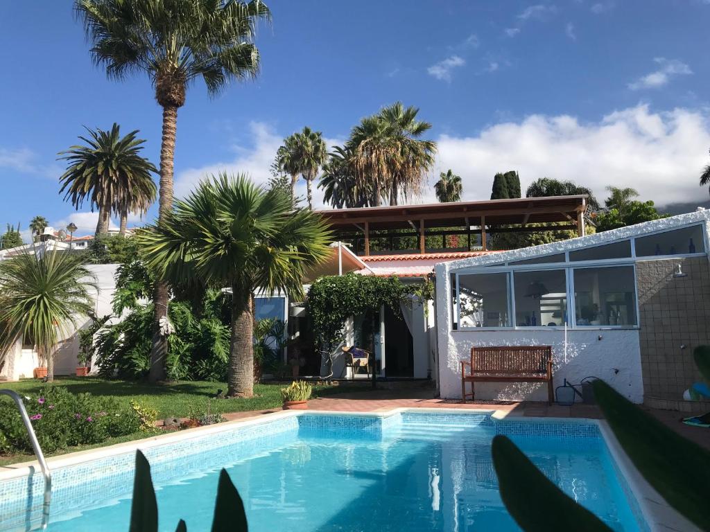 a house with a swimming pool and palm trees at Casa Maria 64 in La Victoria de Acentejo