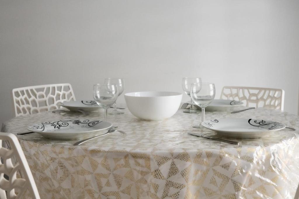 a table with plates and wine glasses on it at Le Casper - Charmant appartement au calme proche centre-ville in Lyon